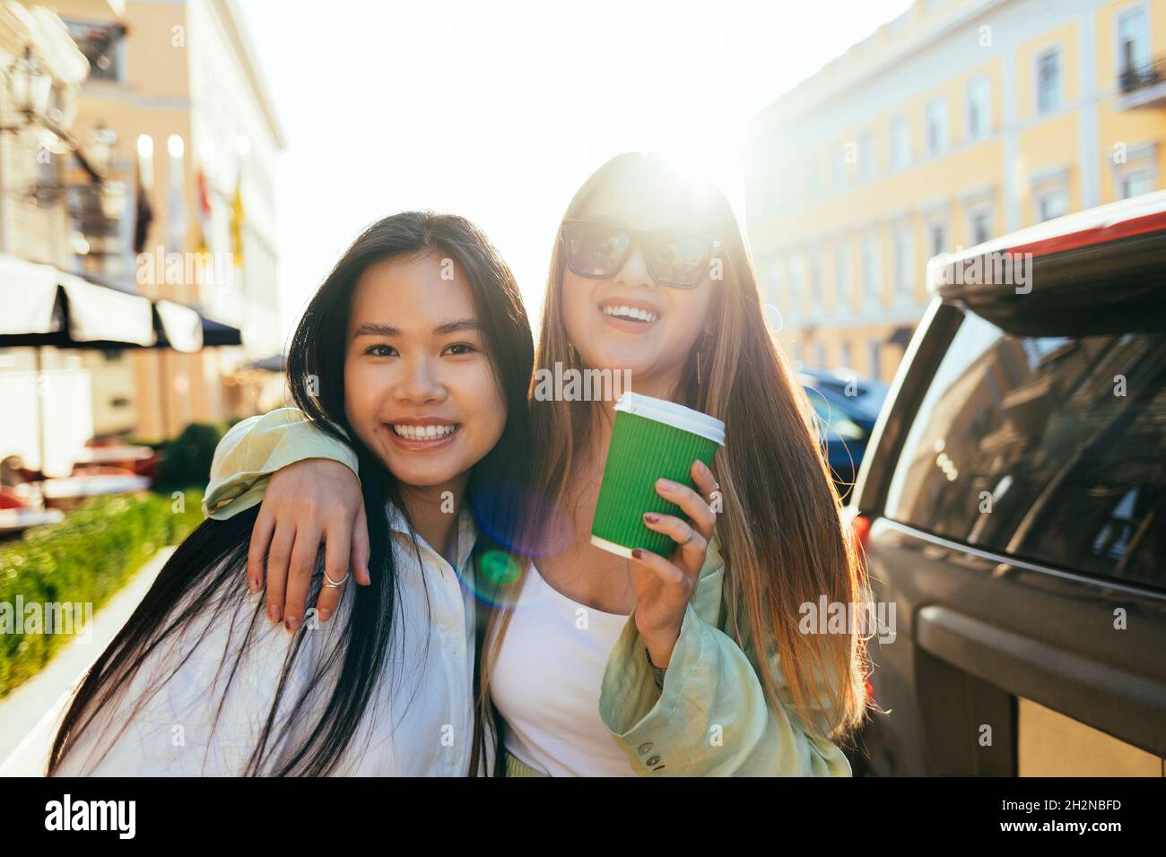 Sorridenti amici femminili con capelli lunghi durante la giornata di sole Foto Stock