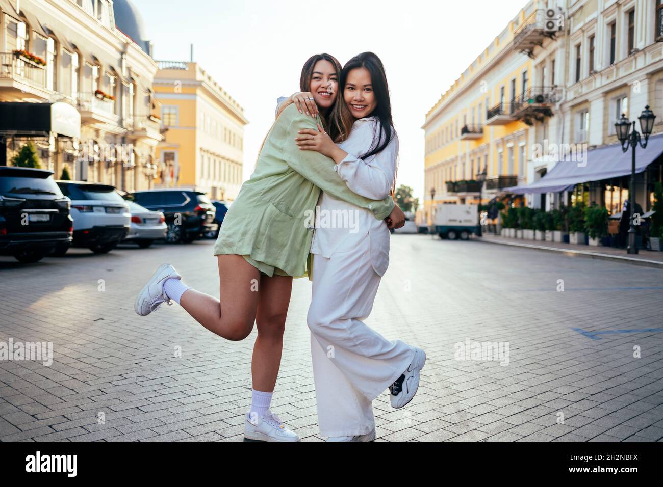 Buone amiche che si abbraccino in città Foto Stock