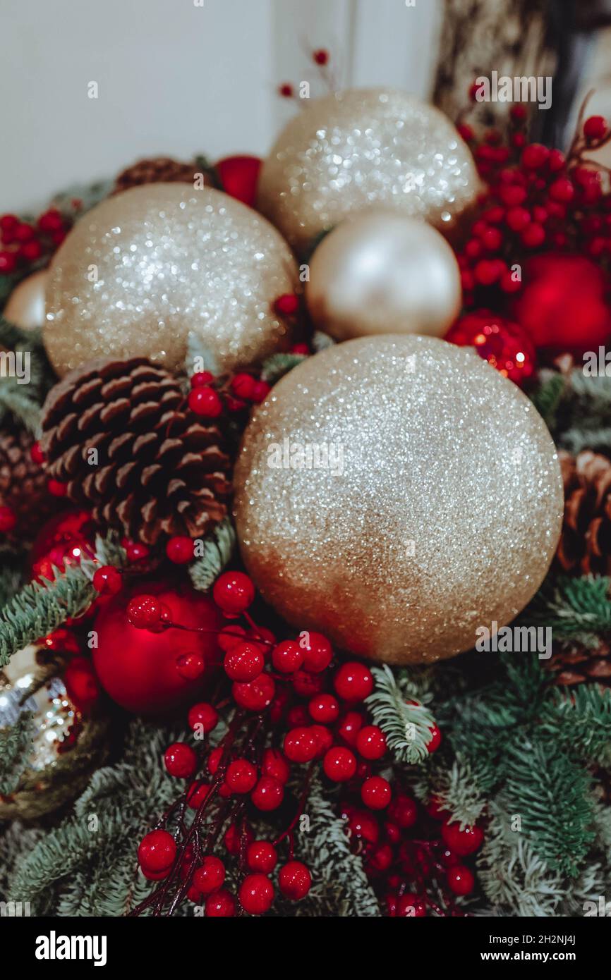 Decorazione natalizia con giocattoli natalizi palle dorate, bacche rosse e coni forestali. Festa invernale. Concetto di anno nuovo. Foto Stock