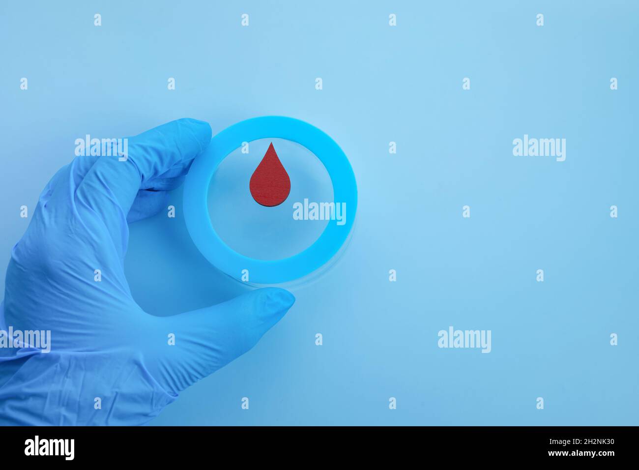 Consapevolezza del giorno del diabete mondiale. Mano che tiene il cerchio blu con goccia di sangue. Foto Stock