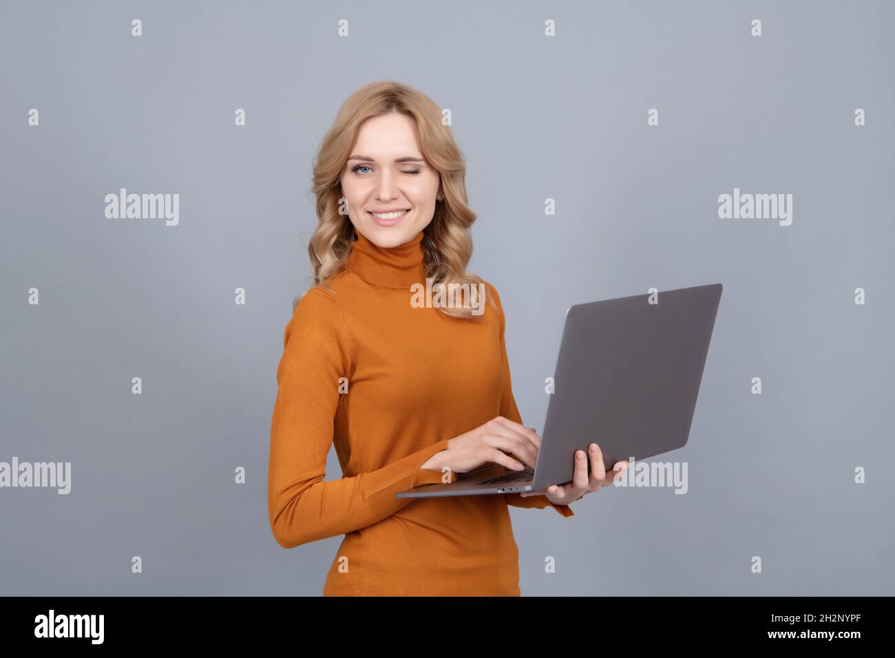 Wireless semplificato. Donna giocosa usa un notebook. Tecnologia wireless. Comunicazione con il computer Foto Stock