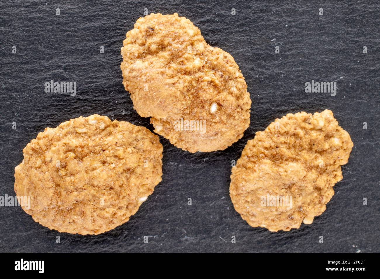 Deliziosi fiocchi multigrain su una tavola di ardesia, primo piano, vista dall'alto. Foto Stock