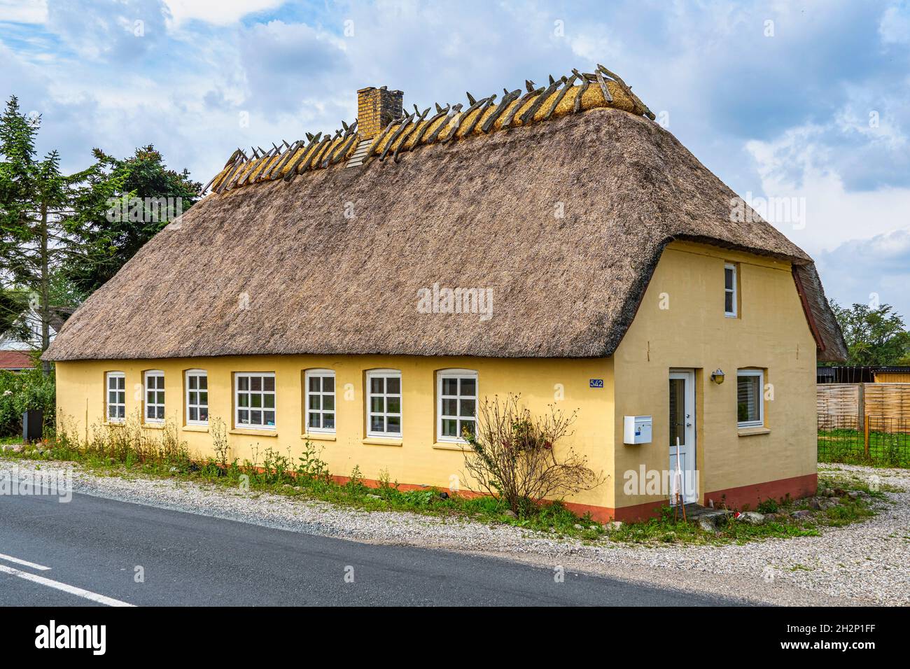 Tipica casa danese gialla. Tradizionale riparazione e costruzione del tetto con paglia e legno. Danimarca, Europa Foto Stock