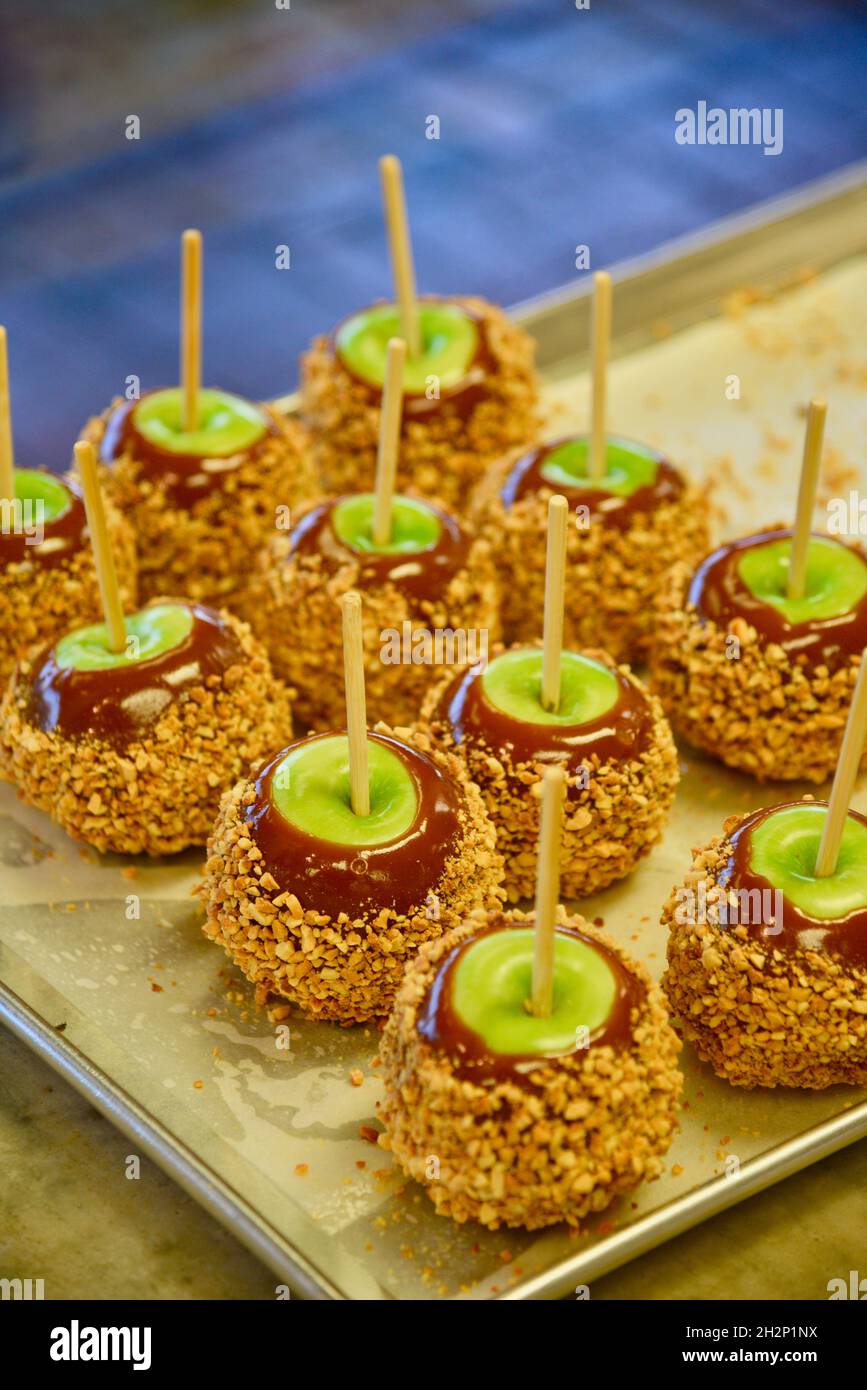 Mele al caramello preparate di recente con mele verdi, caramello e ricoperte con trita di arachidi sul vassoio, Pigeon Forge, Tennessee, USA. Foto Stock