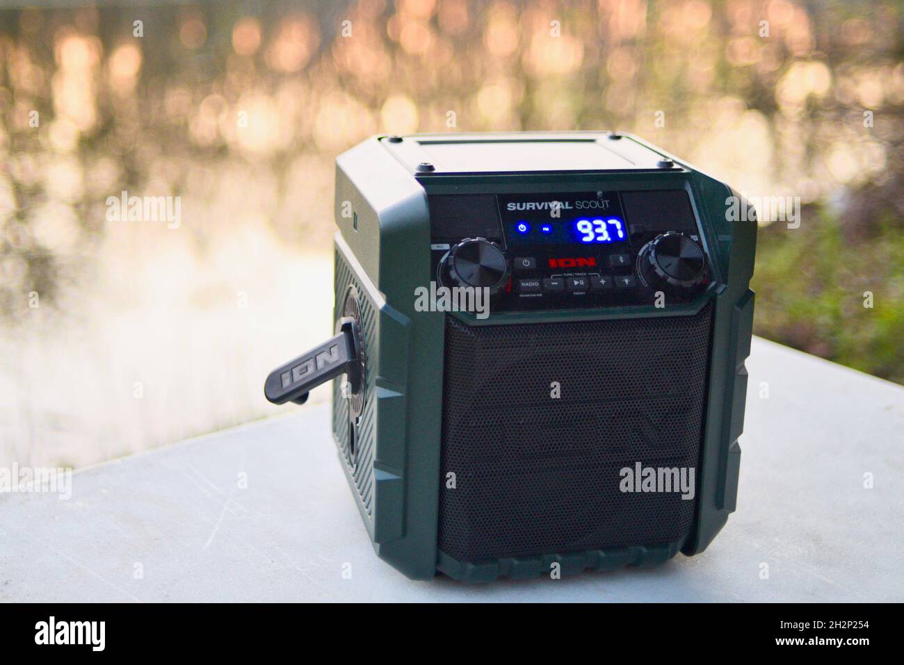 Ion Survival Scout portatile manovella a mano solare alimentato radio meteo di emergenza sul tavolo al campeggio nel bosco durante il tramonto, Woodford, Wisconsin, Stati Uniti Foto Stock
