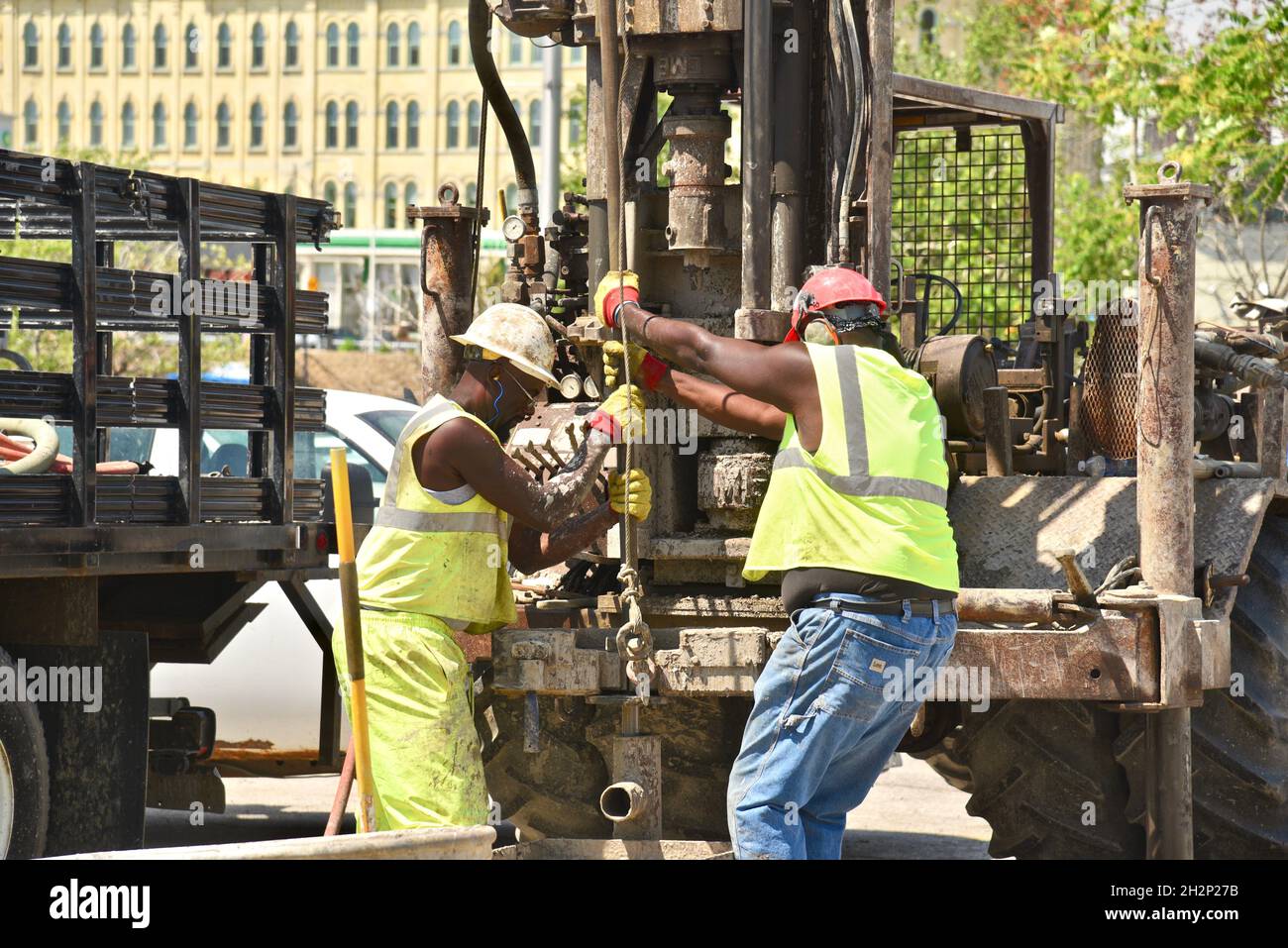 Due operai dell'edilizia afro-americani perforano in tutta sicurezza il foro nel centro città, accanto al fiume Wisconsin, URBAN Renewal, Milwaukee, Wisconsin, USA. Foto Stock