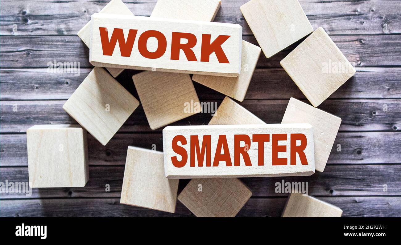 Su blocchi di legno testo lavoro più intelligente su sfondo marrone. Foto Stock