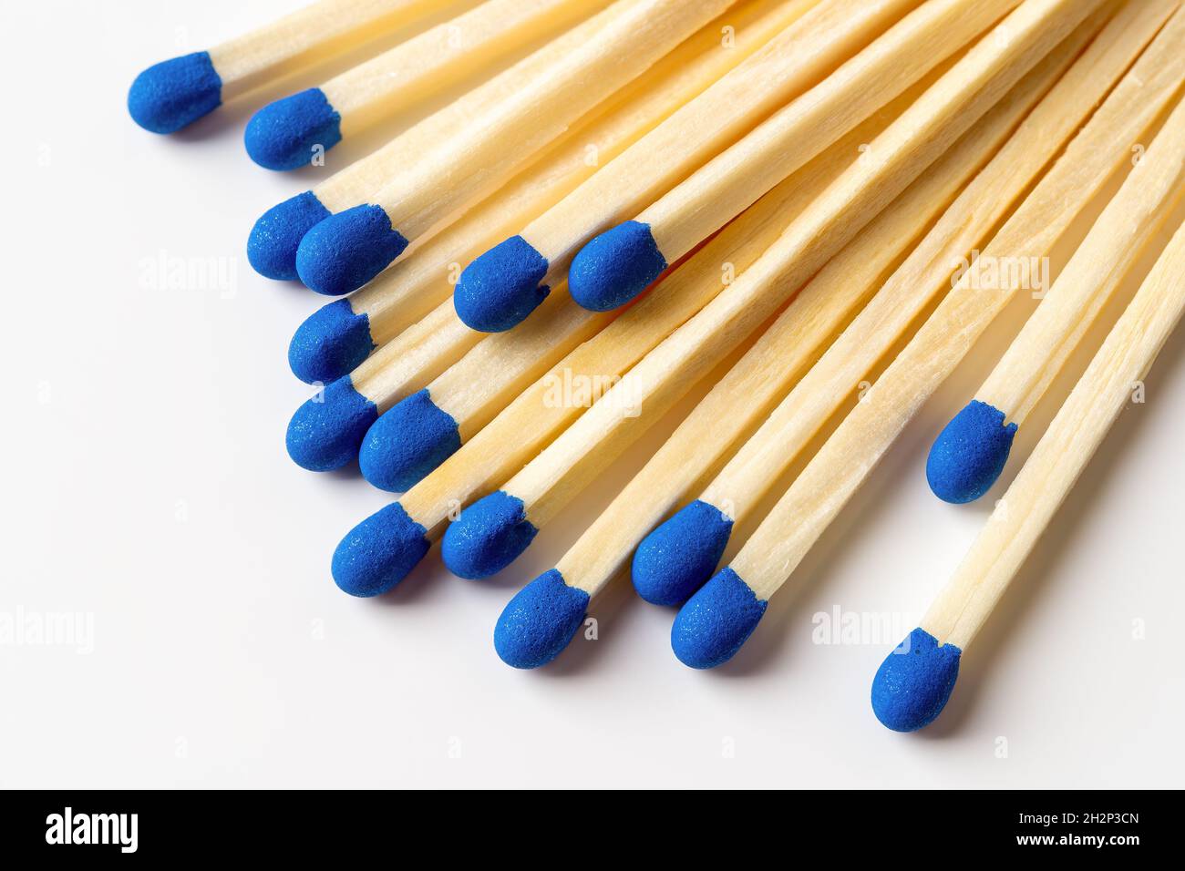 Il legno blu si adatta a uno sfondo grigio chiaro. Fiammiferi con teste macro blu brillante. Partite di legno sparse senza box closeup. Elemento di progettazione Foto Stock