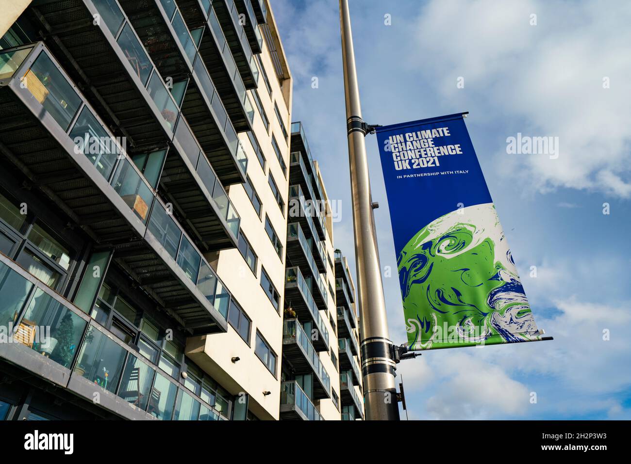 Glasgow, Scozia, Regno Unito. 23 ottobre 2021. Viste del sito durante i preparativi finali con una settimana fino all'apertura della Conferenza ONU sul cambiamento climatico UK COP26 che si terrà a Glasgow nel 2021. PIC; banner COP26 all'esterno dell'edificio di appartamenti vicino alla sede. La carenza di alloggi in città è un grosso problema. Iain Masterton/Alamy Live News. Foto Stock