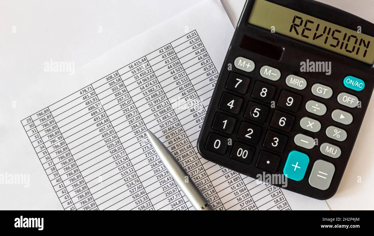Testo di revisione scritto in una calcolatrice. Business Concept rivisita qualcosa per migliorarlo su sfondo bianco con documenti e un evidenziatore e chiave Foto Stock