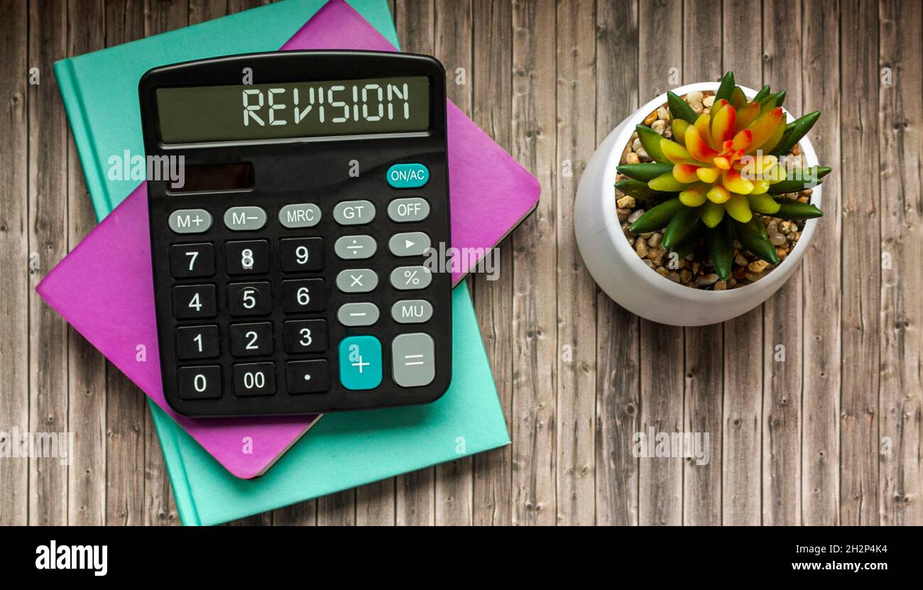 Revisione, testo sulla calcolatrice. Quaderni colorati e cactus su sfondo in legno Foto Stock