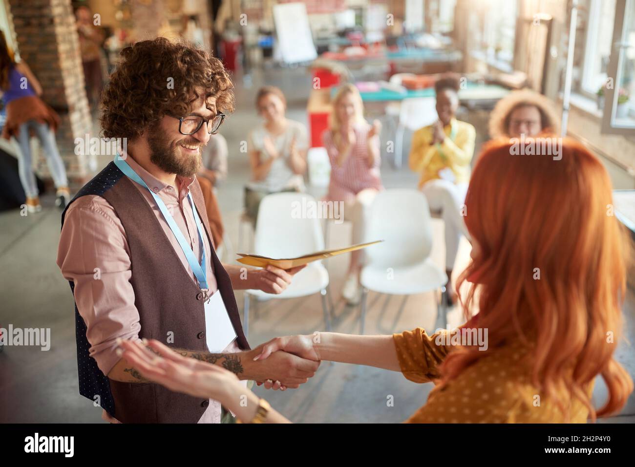 Giovane dipendente che riceve un certificato di formazione di successo Foto Stock