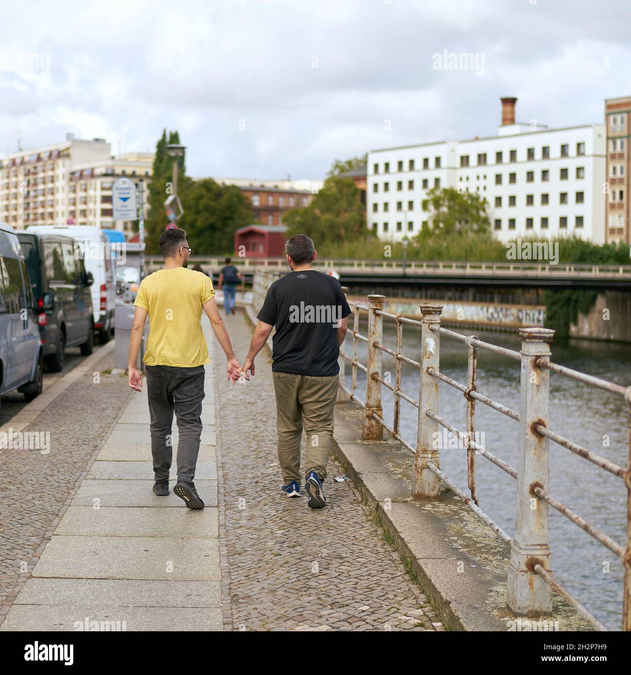 Sentiero sulla riva del fiume Sprea a Berlino con coppia omosessuale a piedi Foto Stock