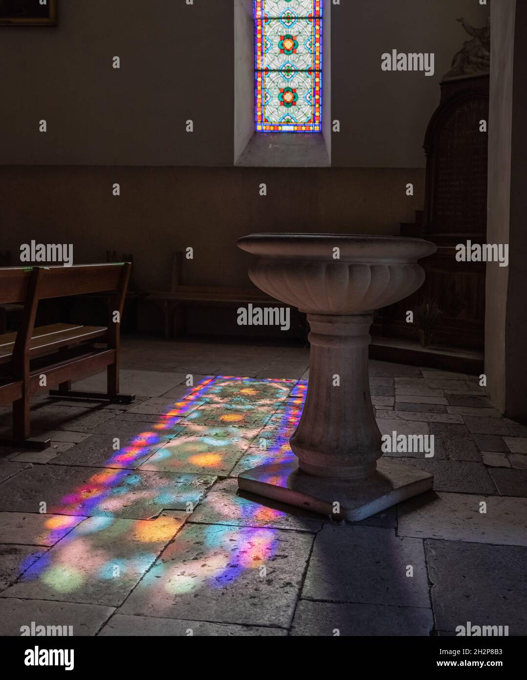 La luce del sole diffonde l'immagine multicolore della vetrata a St-Pierre Eglise, Cabrerets, Lot Valley Francia Foto Stock