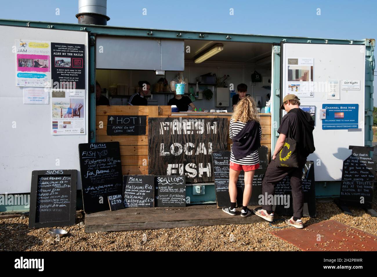 Persone clienti che acquistano frutti di mare pasti cibo spuntini presso Dungeness snack Shack capanna di pesce che vendono pesce fresco locale in Kent Inghilterra Gran Bretagna Regno Unito KATHY DEWITT Foto Stock