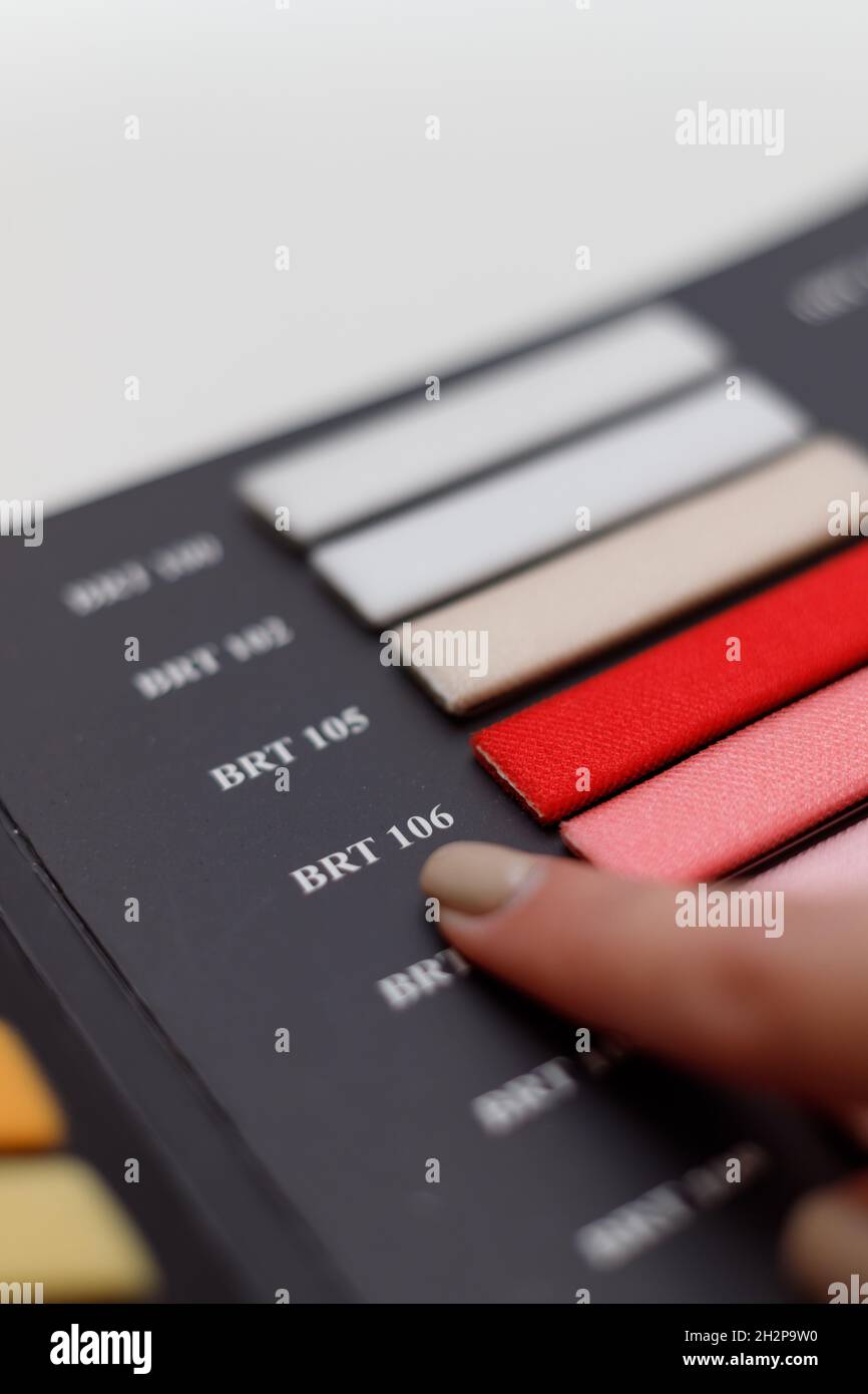 Mano femminile scelta del colore giusto dal catalogo, primo piano Foto Stock