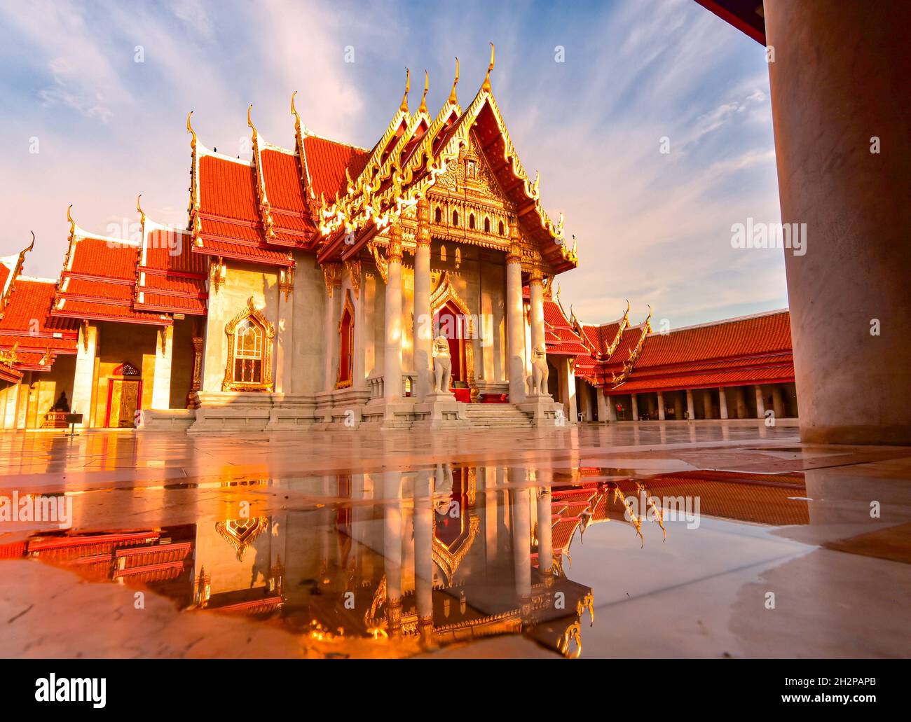 Splendido scenario di Wat Benchamabophit (tempio) o il Tempio di marmo con riflessione d'acqua. Un maestoso tempio buddista con una porta decorata e oro Foto Stock