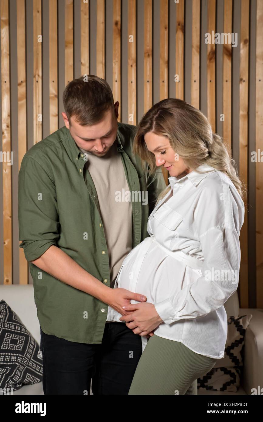 La coppia felice guarda teneramente al ventre della donna incinta Foto Stock