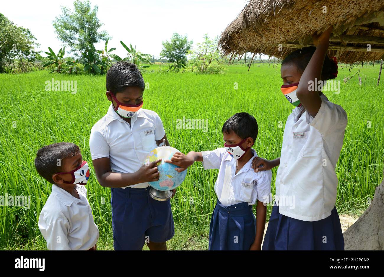 I bambini della scuola del villaggio remoto stanno imparando la classe di geografia fuori dei loro locali della scuola durante la situazione di Covid-19 all'isola di Sundarban. Foto Stock