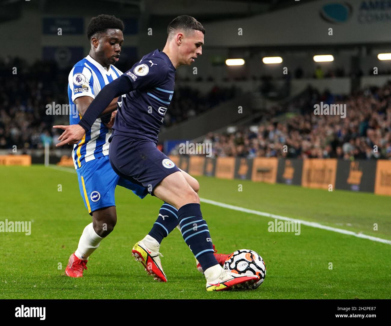 Brighton e Hove Albion's Tariq Lamptey (a sinistra) e Phil Foden di Manchester City combattono per la palla durante la partita della Premier League allo stadio AMEX di Brighton. Data foto: Sabato 23 ottobre 2021. Foto Stock