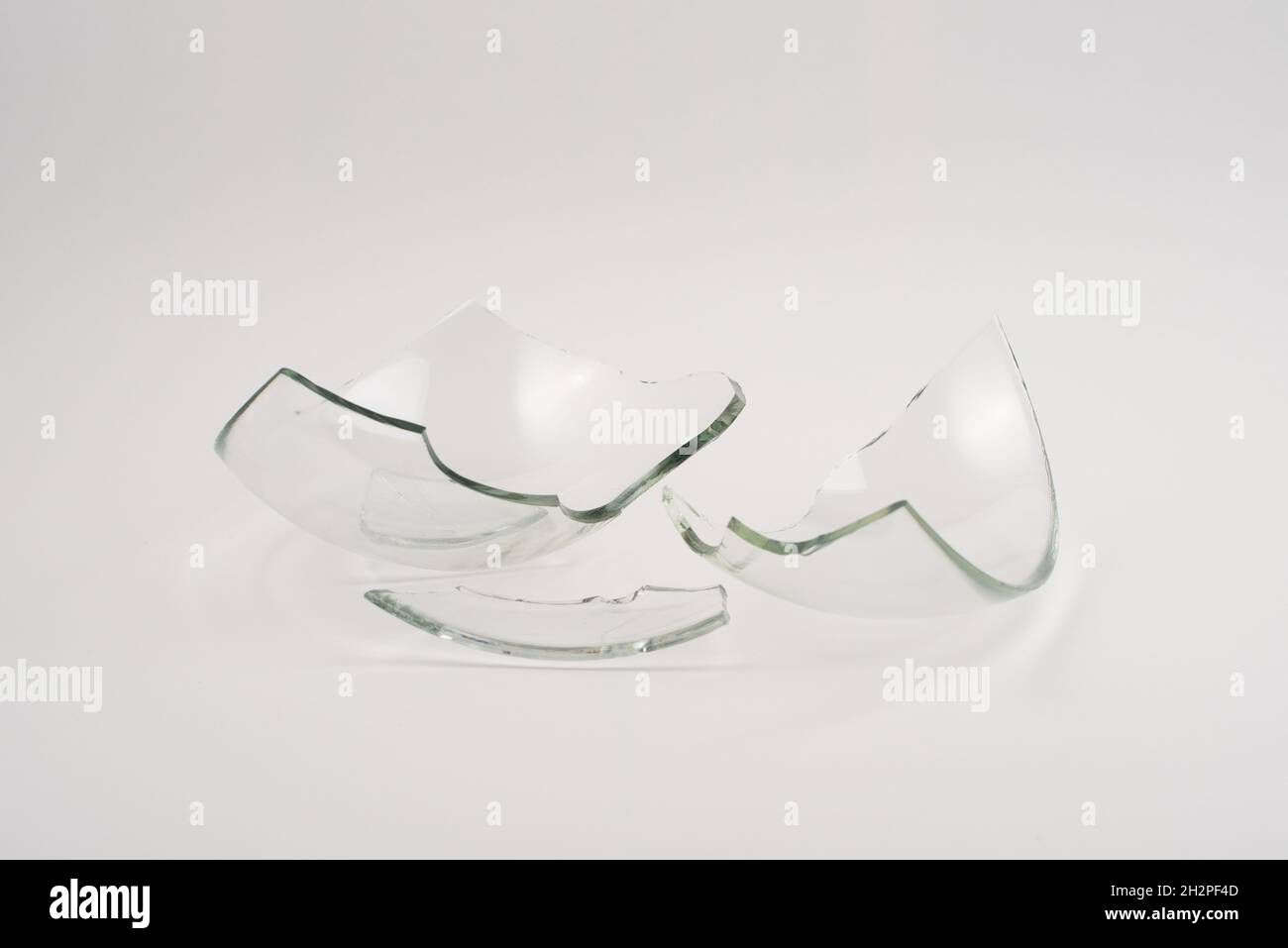 Pezzi di vetro rotti su sfondo bianco. Foto Stock