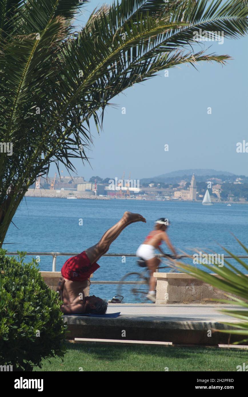 Europa, Spagna, Baleari, Maiorca, Palma di Maiorca, Mann macht Joga-Übung an der Strandpromenade von Palma, Badia de Palma Foto Stock