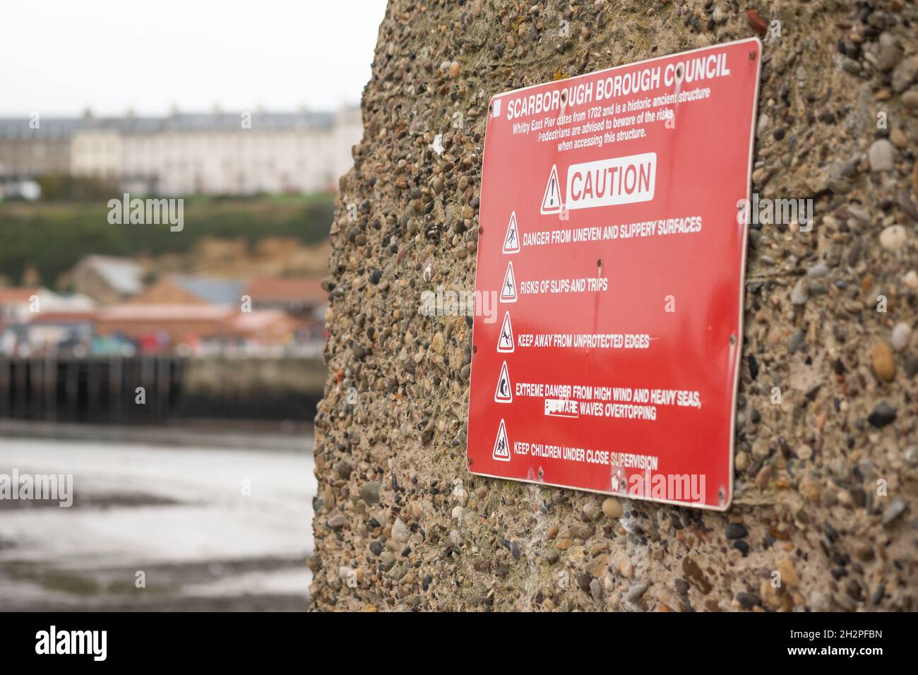 Whitby, Yorkshire, Regno Unito – Ottobre 20 2021. Scarborough Borough Consiglio segno di avvertimento e di attenzione attaccato a un muro di pietra che consiglia il potenziale Foto Stock