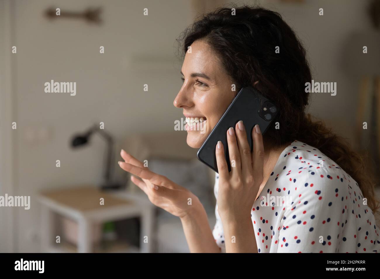 Eccitata donna latina ridente che parla sul cellulare Foto Stock