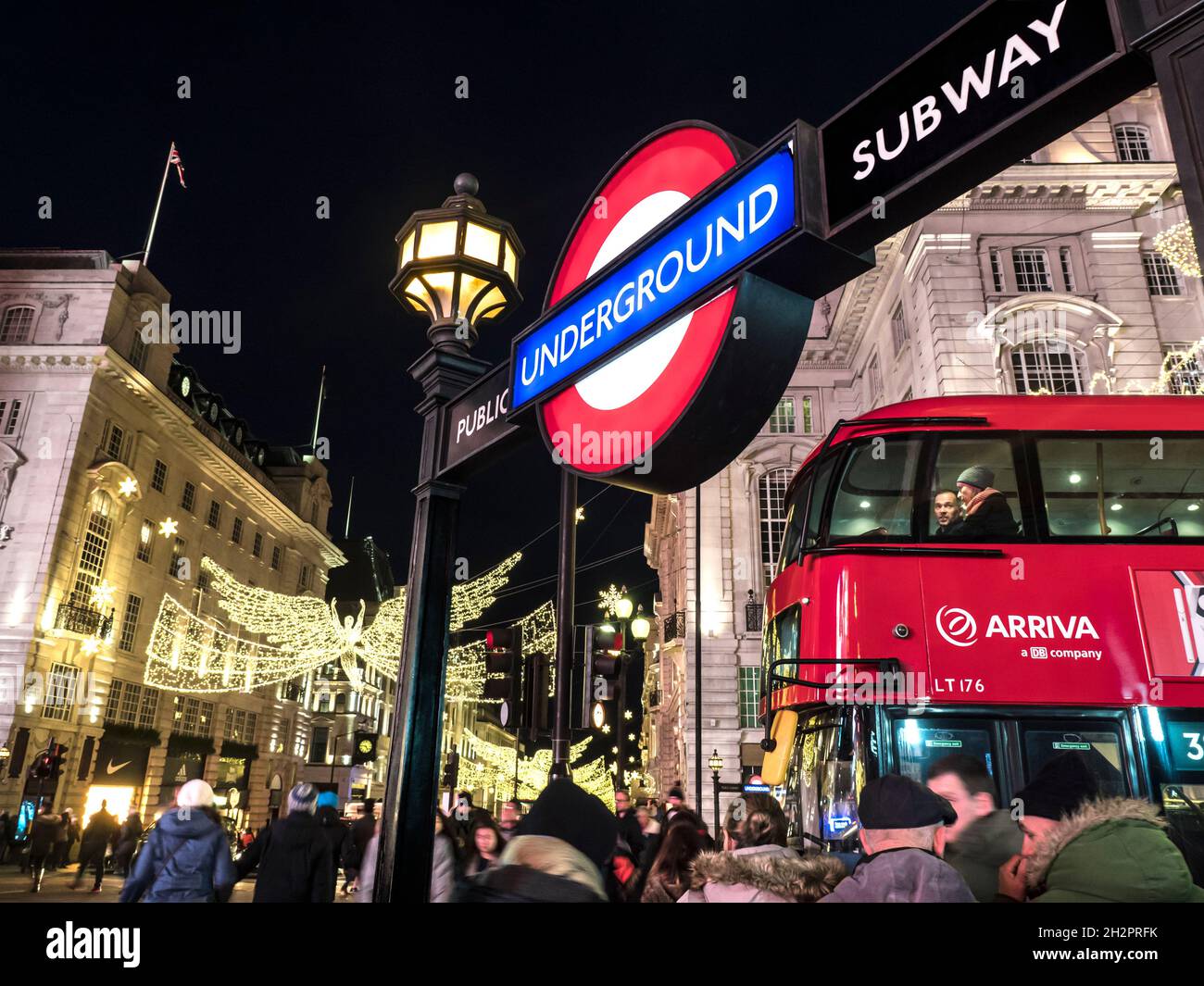 REGENT STREET LUCI DI NATALE la gente si offusava con il rosso Londra autobus Natale acquirenti e Londra metropolitana metropolitana ingresso alla stazione della metropolitana di Piccadilly London UK TFL trasporto per Londra a Natale Foto Stock