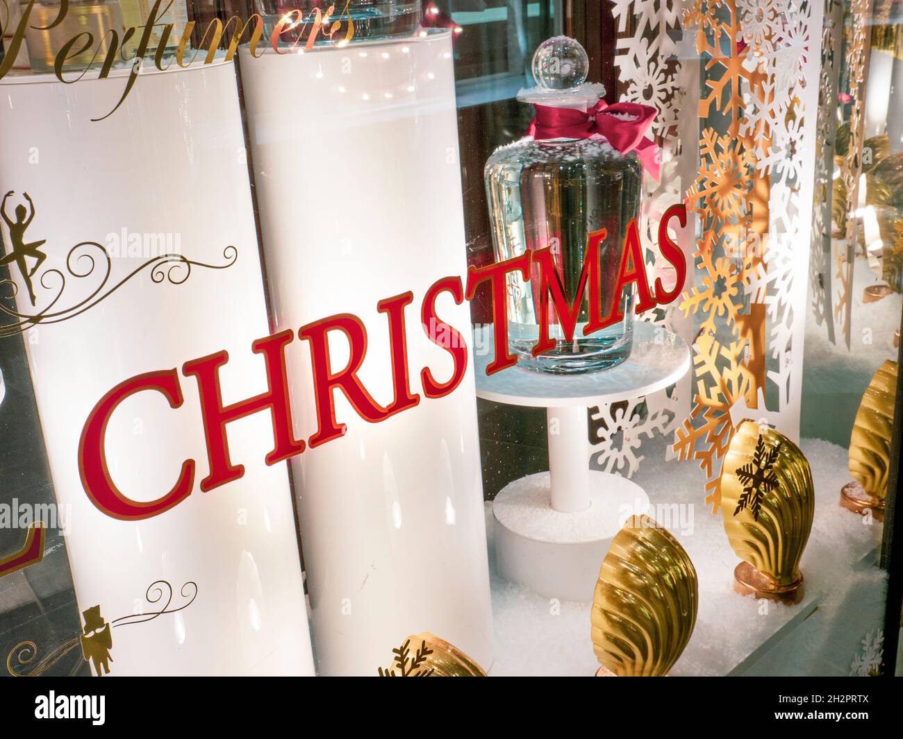 CHRISTMAS SHOP WINDOW semplice elegante negozio di profumeria festiva elegante vetrina vestita con fanali da palco per il Natale di Londra UK Foto Stock