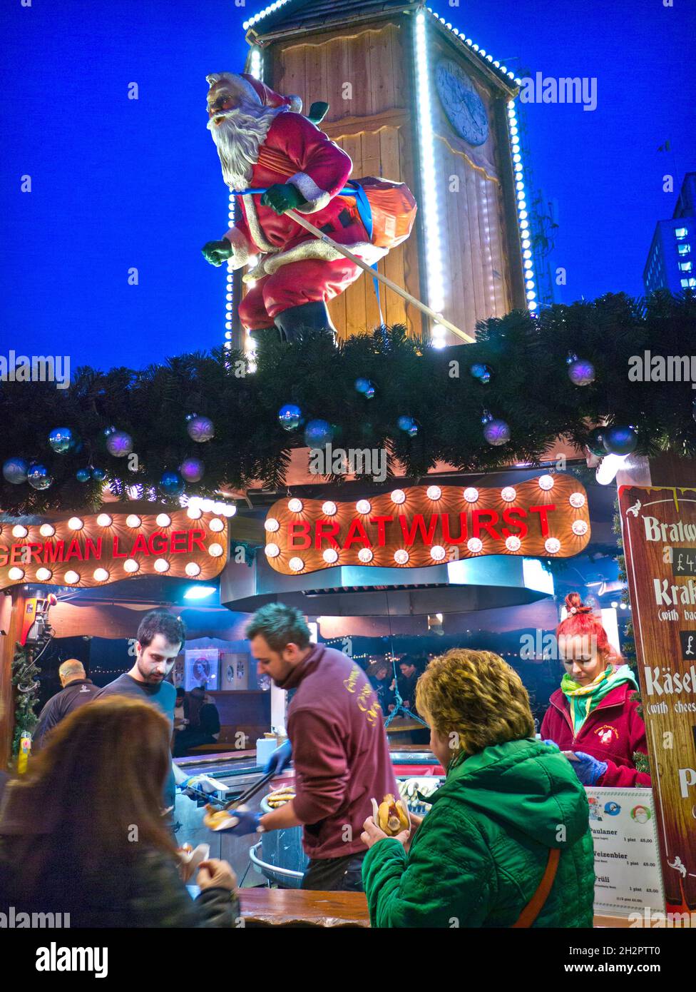 SOUTHBANK OUTDOOR TAKEAWAY GERMAN CHRISTMAS MARKET Food Stall German Christmas Market food stalla con sci Padre Natale illuminato di notte South Bank London UK Foto Stock