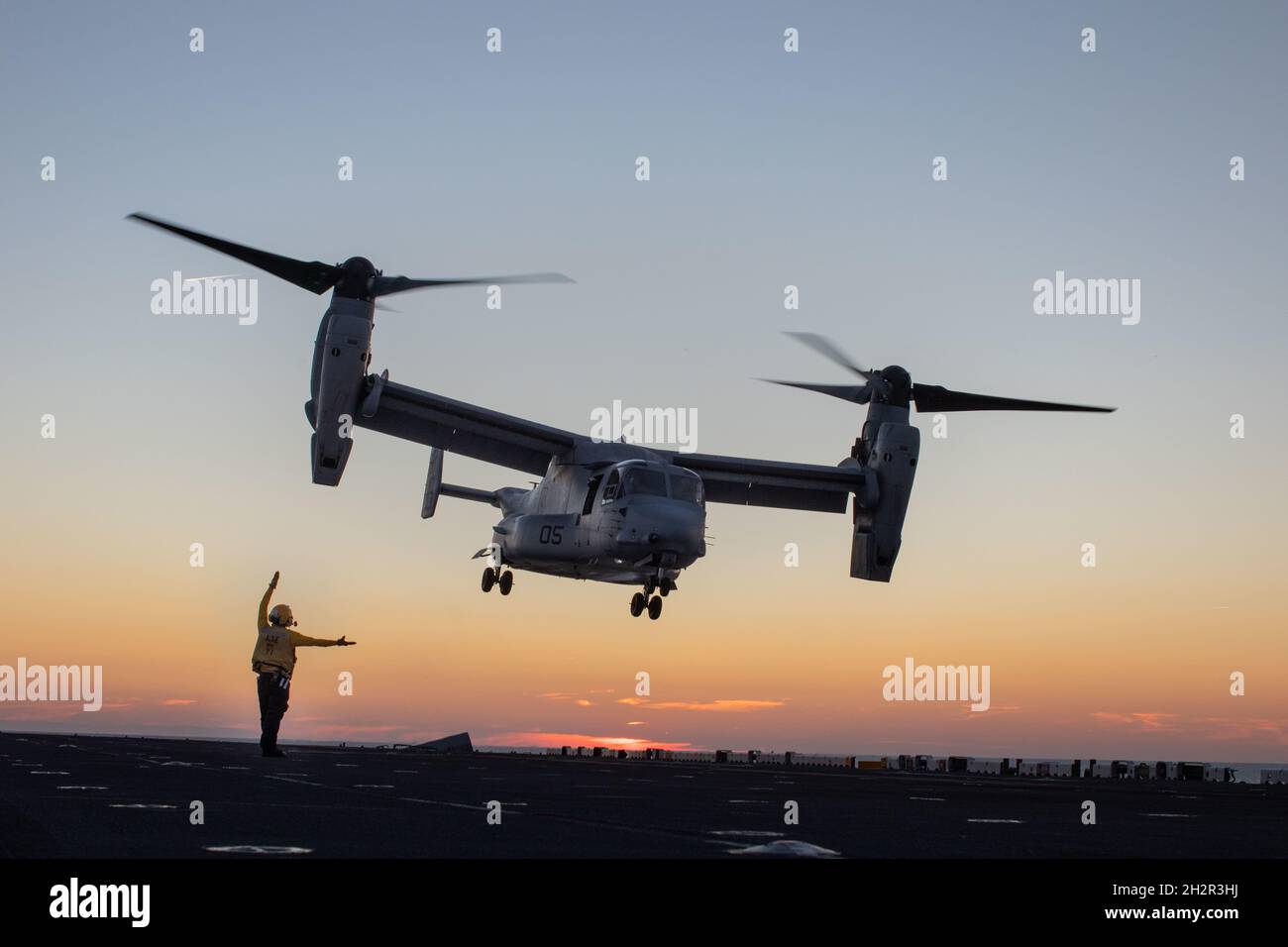 Un Navy Sailor degli Stati Uniti assegnato a una nave d'assalto anfibio USS Kearsarge (LHD 3) dirige lo sbarco di un MV-22 Osprey assegnato a Marine Medium Tiltrotor Squadron (VMM) 263, durante operazioni di volo a bordo di una nave d'assalto anfibio USS Kearsarge (LHD 3), 20 ottobre 2021. VMM-263 è l'elemento di combattimento aereo per la 22a unità di spedizione marina. Kearsarge, l'ammiraglia per il 22° MEU e lo Squadrone anfibio (PHIBRON) 6, è in corso per la formazione integrata PHIBRON-MEU (PMINT) in preparazione di un futuro impiego. PMINT è il primo periodo in mare del programma di formazione predeploy della MEU; si tratta di un periodo di tempo Foto Stock