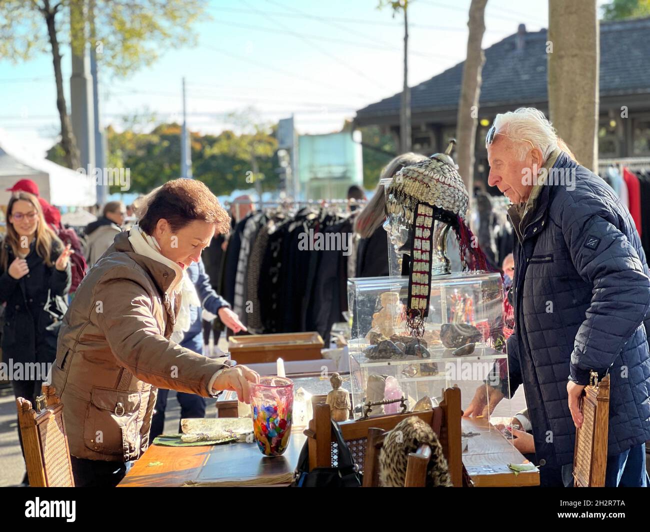 Shopping al mercato delle pulci di Zurigo, Burkliplatz il sabato pomeriggio. Lady sta negoziando il prezzo di un vaso. Foto Stock