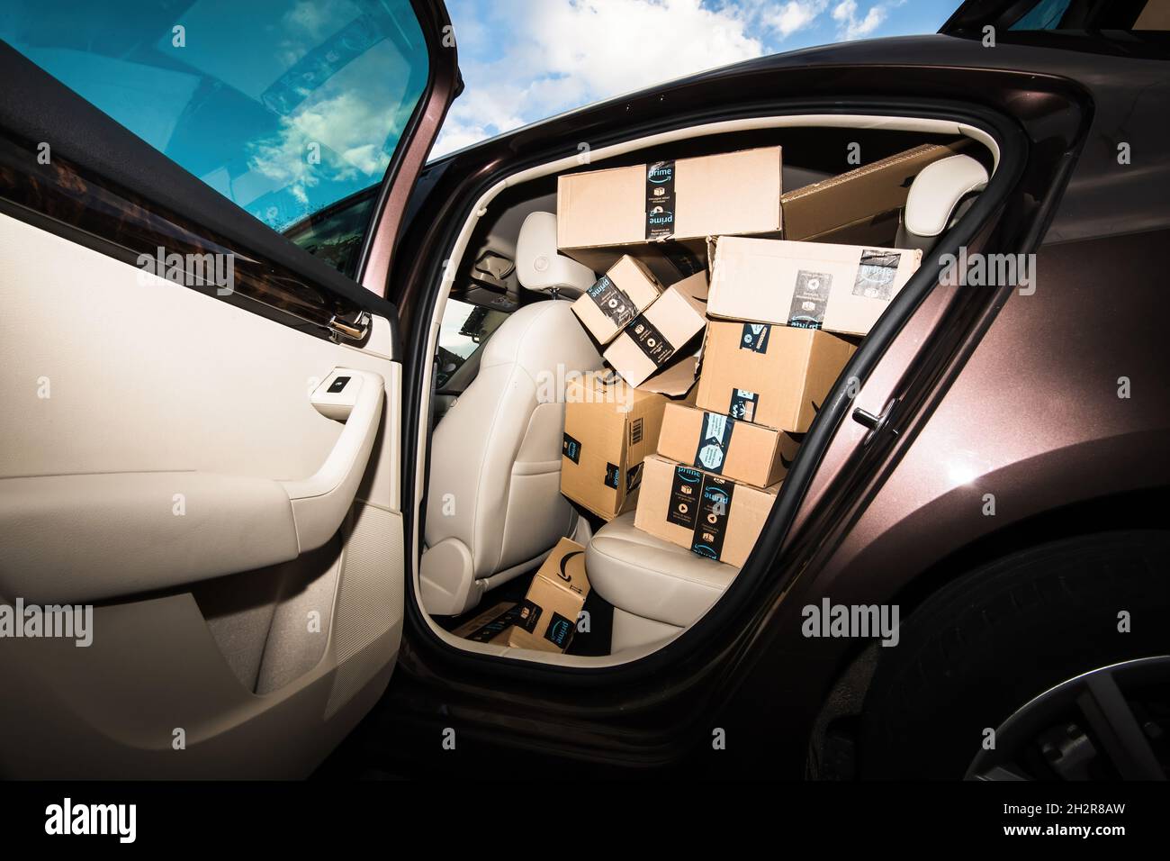 Apri la porta dell'auto di lusso con interni in pelle e diversi pacchi in  cartone Amazon prime Foto stock - Alamy
