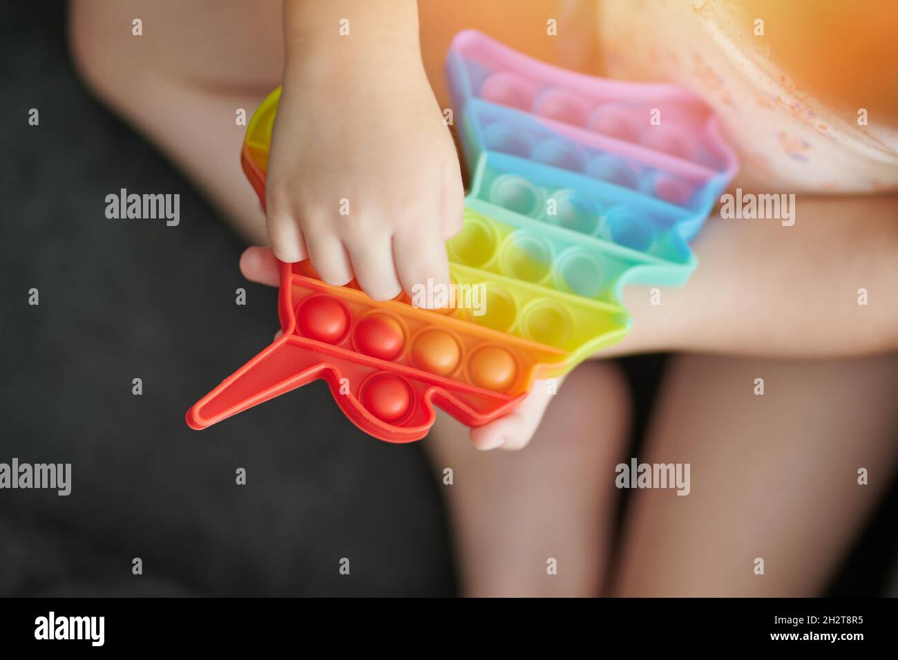 Primo piano della mano spingere popit giocattolo su sfondo sfocato Foto Stock