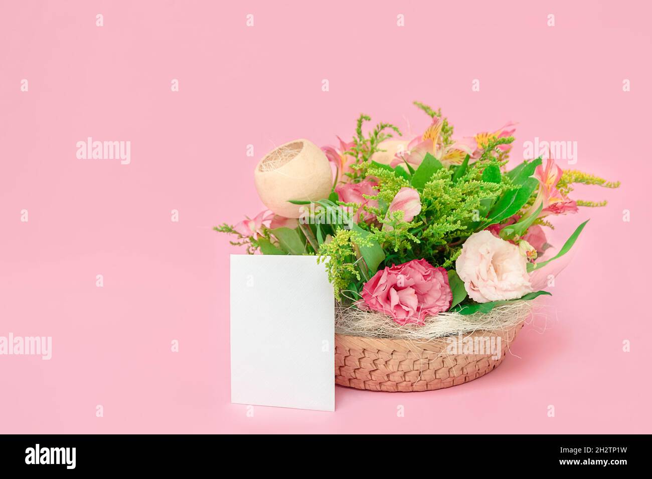 Fresco bouquet bello con fiori rosa su sfondo rosa pastello con carta bianca vuota, mockup, spazio copia Foto Stock