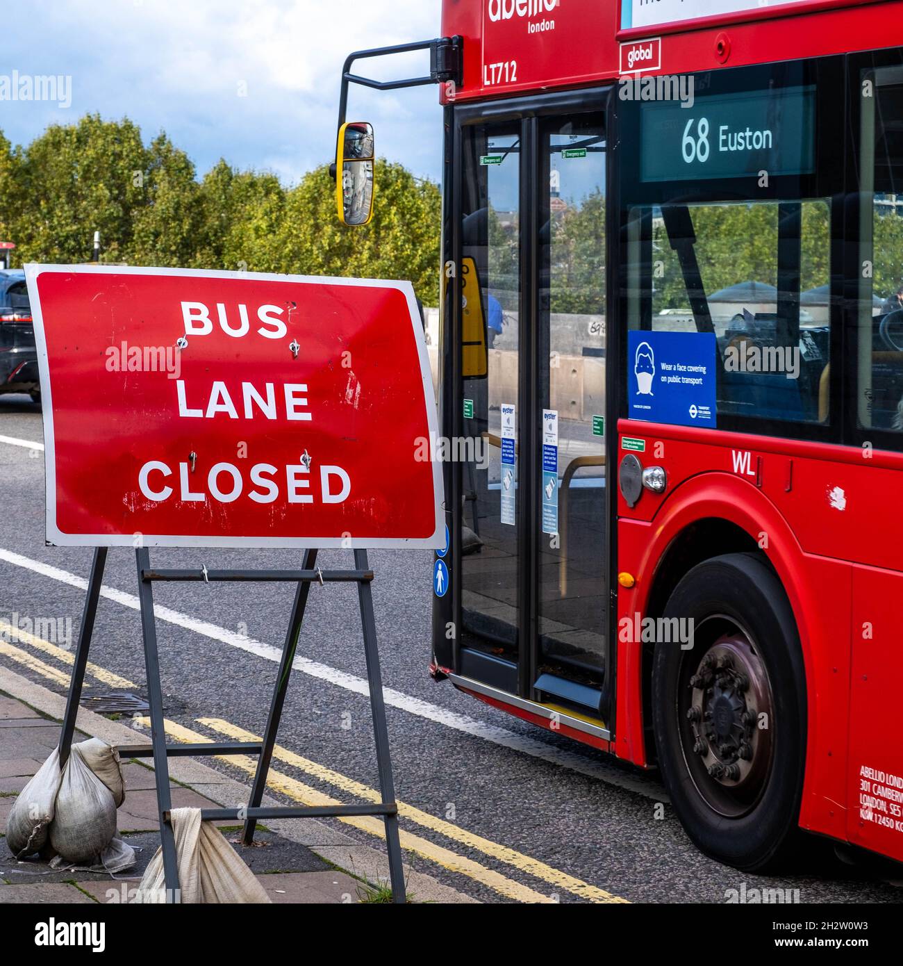 Un tradizionale Red London Double Decker Bus Nest a Un Bus Lane chiuso strada segnale e non persone Foto Stock