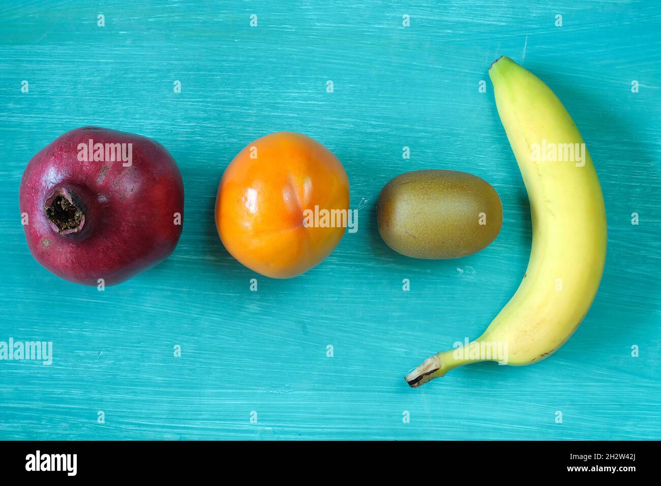 Frutta sul tavolo, melograno, frutta kaki, kiwi, banana, alimentazione sana, dieta, concetto di cibo Foto Stock