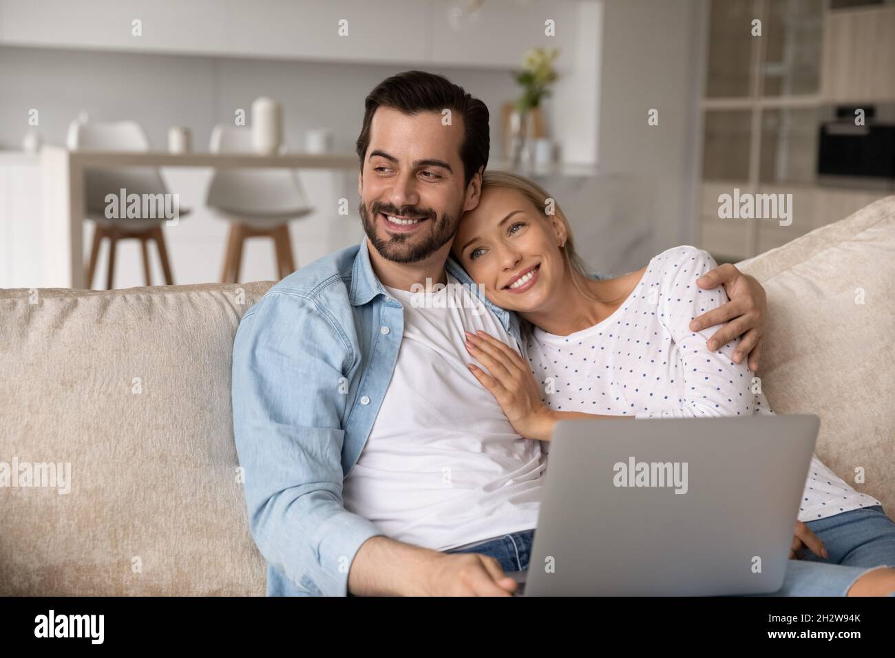 Buon legame sognante giovane coppia di famiglia utilizzando il computer. Foto Stock