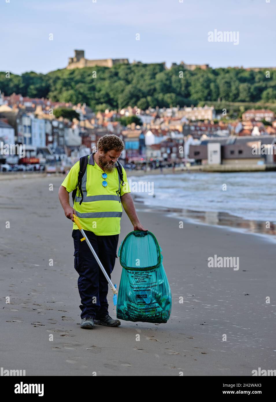 Una commissionatrice di lettiere di plastica pulita di consiglio sulla spiaggia di Scarborough North Riding of Yorkshire, North Yorkshire Inghilterra UK Foto Stock