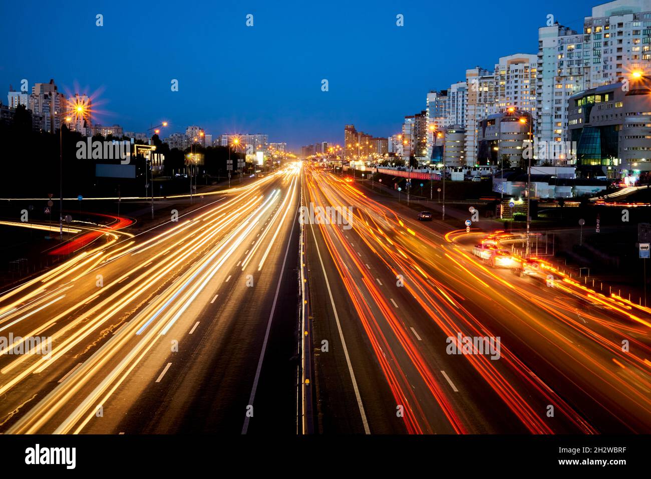 Strada splendente notturna con auto e luci in movimento Foto Stock