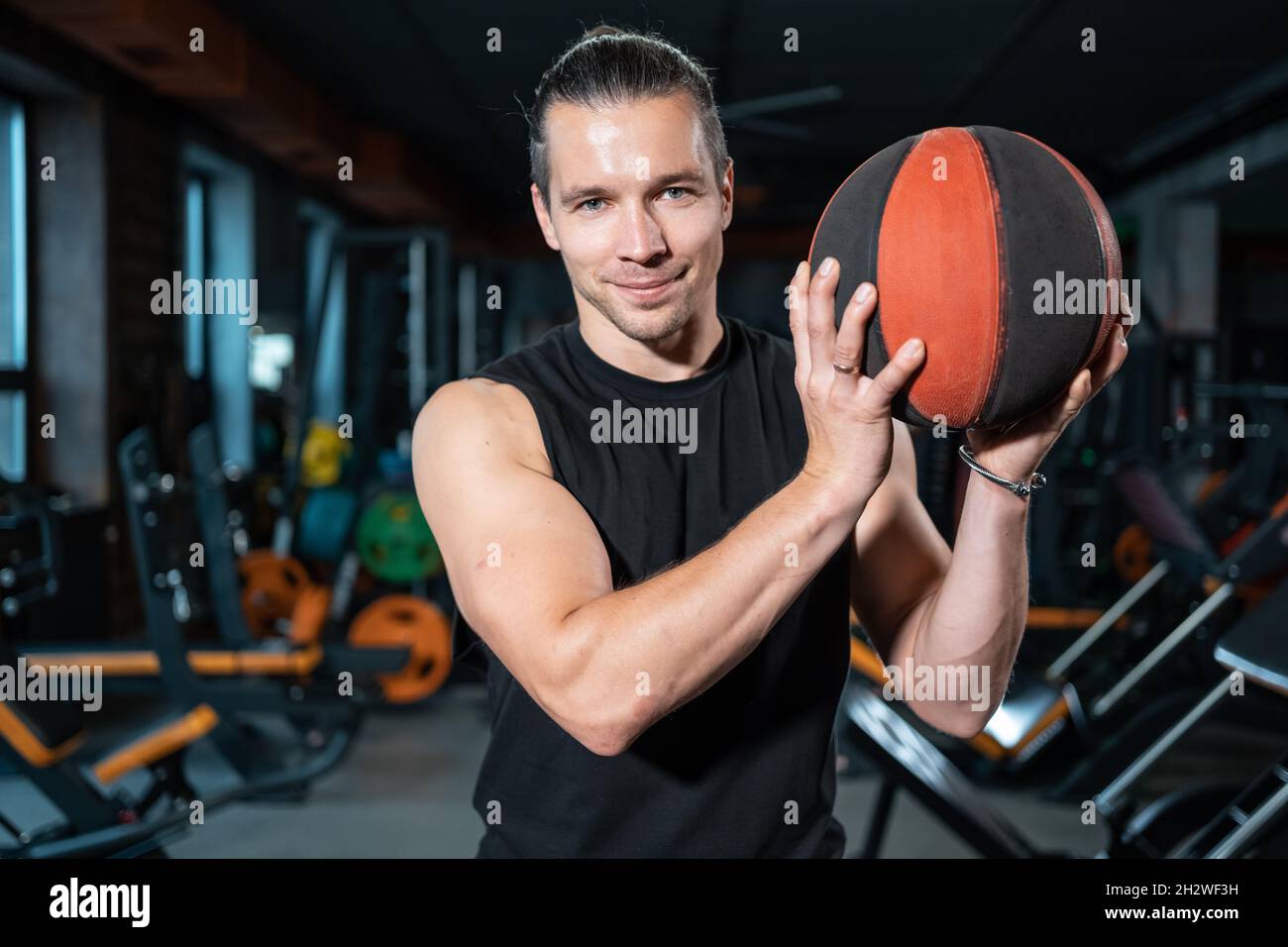 il giovane atleta maschio con basket o palla medica si allena in palestra Foto Stock