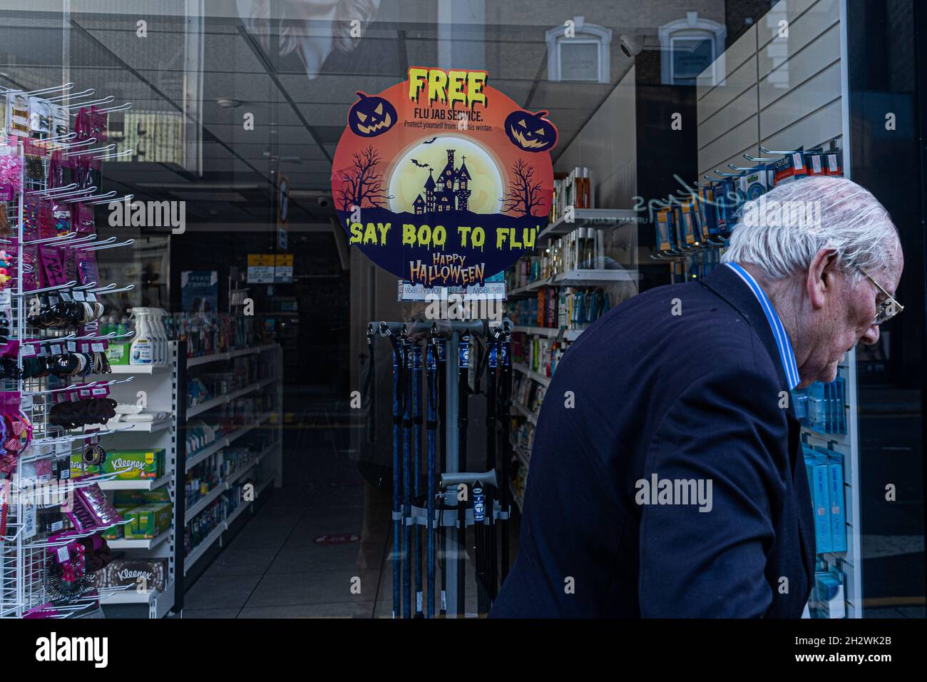 WIMBLEDON LONDRA, REGNO UNITO. 24 Ott 2021. Un segno sulla finestra di una farmacia nel centro della città di Wimbledon che offre un servizio libero di influenza dice 'boo a flu' con molte pratiche di GP e farmacie che offrono il jab di flu nella corsa fino all'inverno. Il governo ha intrapreso una campagna di vaccino antinfluenzale sopra le paure di un covid ed epidemie di flu che mettono a dura prova l'NHS. Credit: amer Ghazzal/Alamy Live News Foto Stock