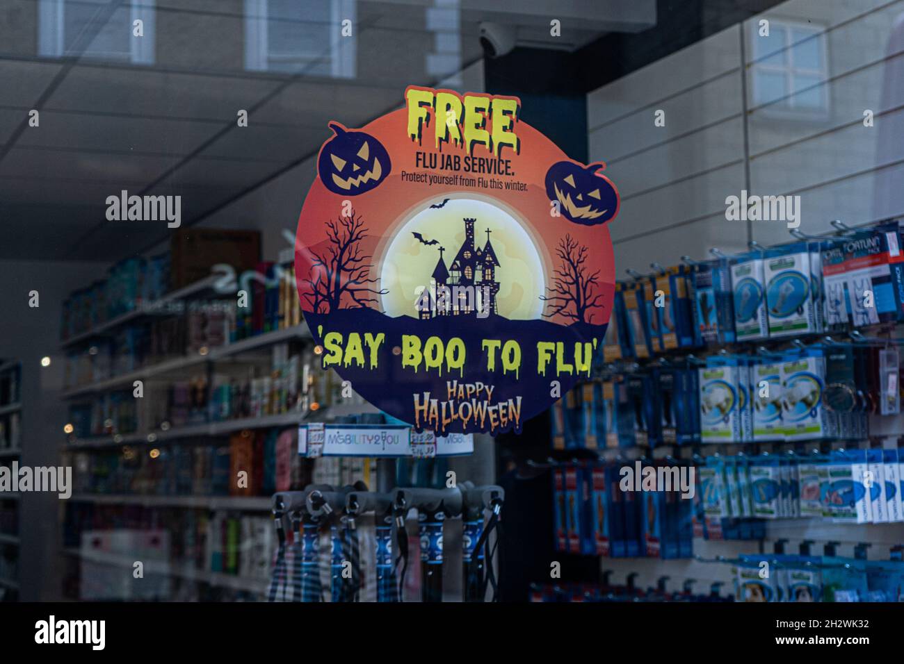 WIMBLEDON LONDRA, REGNO UNITO. 24 Ott 2021. Un segno sulla finestra di una farmacia nel centro della città di Wimbledon che offre un servizio libero di influenza dice 'boo a flu' con molte pratiche di GP e farmacie che offrono il jab di flu nella corsa fino all'inverno. Il governo ha intrapreso una campagna di vaccino antinfluenzale sopra le paure di un covid ed epidemie di flu che mettono a dura prova l'NHS. Credit: amer Ghazzal/Alamy Live News Foto Stock