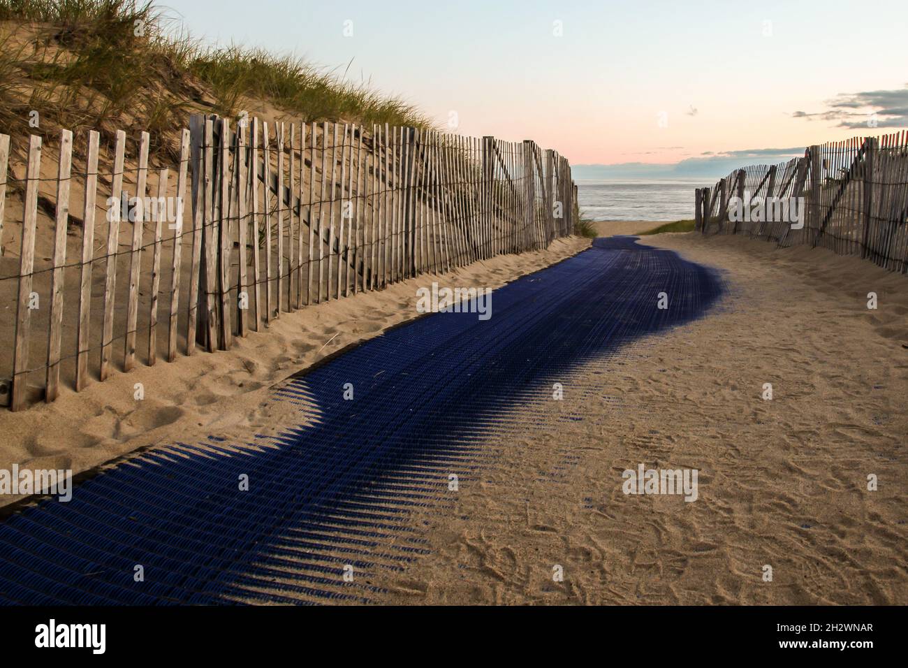 Recinzione sulla spiaggia con sabbia e alba Foto Stock