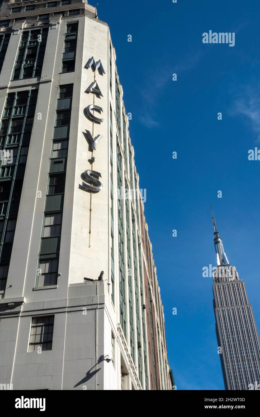 Macy's Department Store Sign in Eight Avenue e West 34th Street con l'Empire state Building in background, 2021, NYC, USA Foto Stock