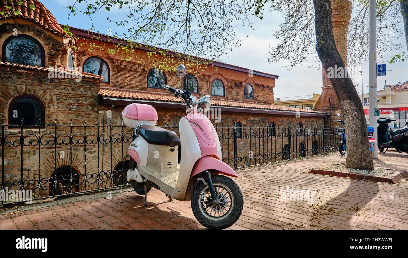 Vintage e stile retrò rosa mobiletto e scooter (vespa) in piedi sul cammino acciottolato Foto Stock