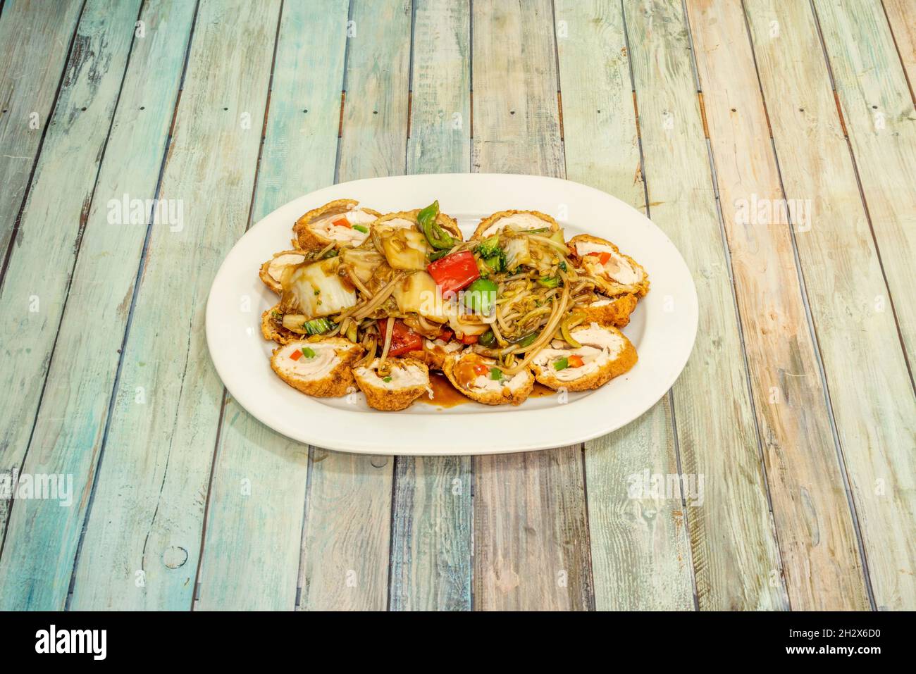 Ricetta peruviana di pollo arrotolato con tagliatelle e verdure saltate con  salsa di soia su tavola di legno Foto stock - Alamy