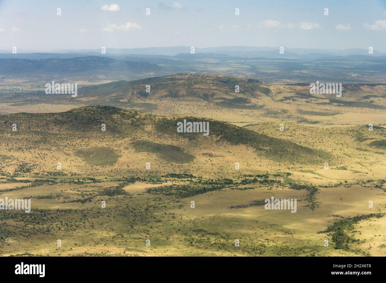 Vista aerea di ondulate colline semi aride punteggiate di alberi, Kenya Foto Stock