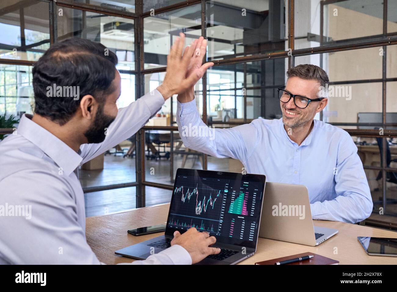 Due felici successo diversi investitori commercianti che danno cinque alti. Foto Stock